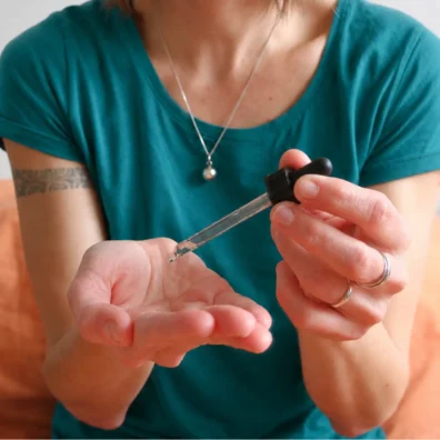 Application d'une huile essentielle avec une pipette lors d'une séance de formation en aromathérapie énergétique