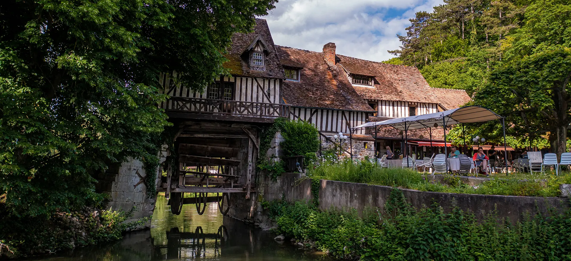 Vue du Moulin d'Andé, centre artistique et culturel en Normandie, lieu d'accueil de la formation en aromathérapie énergétique d'Agnès Addey — monument historique au bord de l'eau