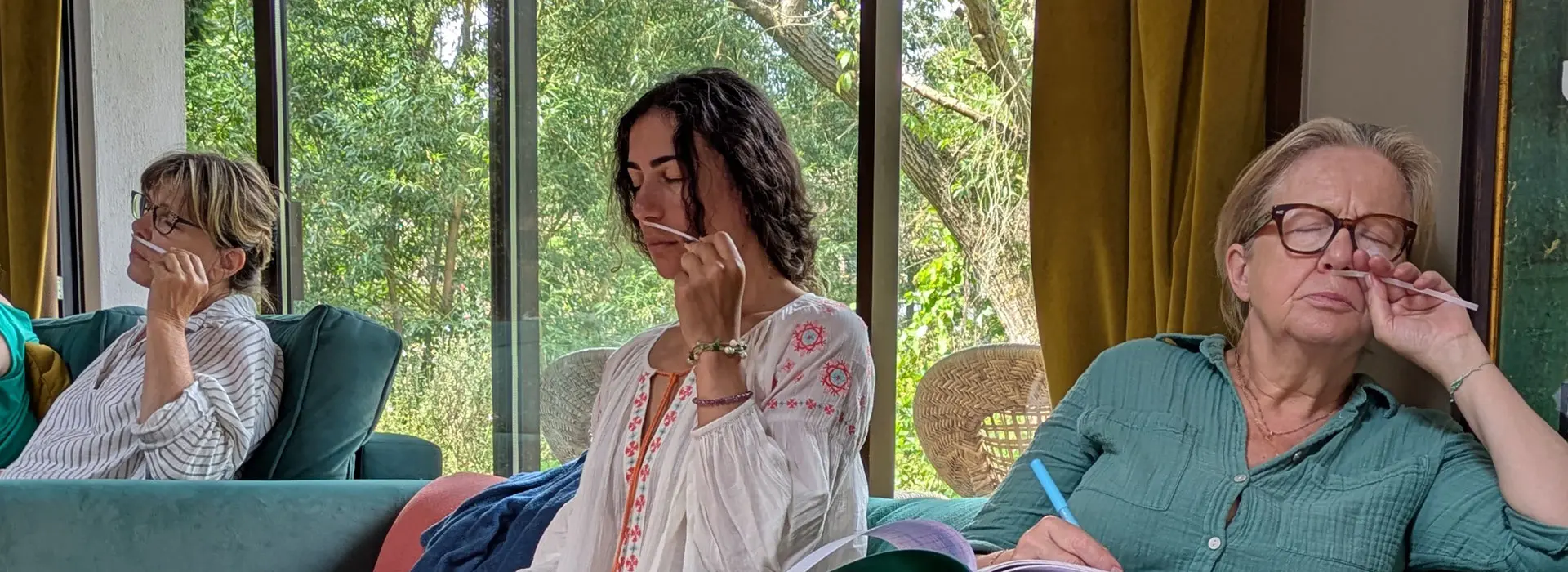 Trois participantes en train de sentir des huiles essentielles sur mouilleurs lors d'une session de formation en aromathérapie énergétique au Moulin d'Andé, Normandie
